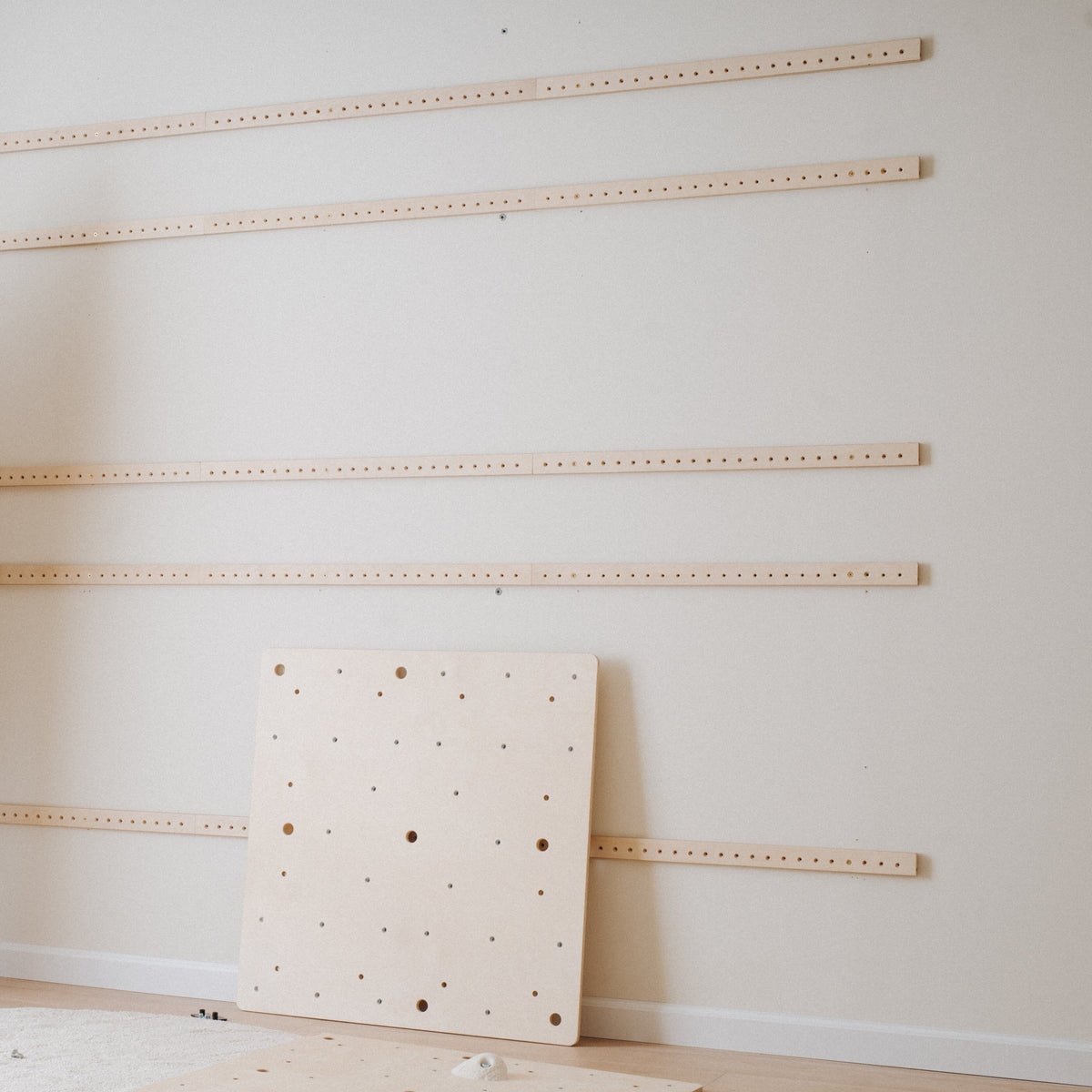 Climbsy mounting rails fixed to a wall with a birch plywood panel ready to hang