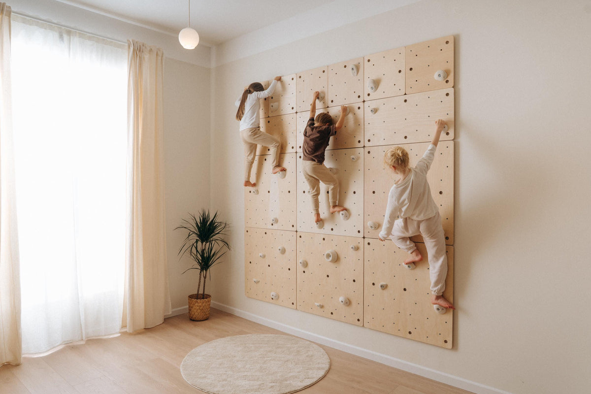 Kids wooden climbing wall with modular panels mounted on a wall
