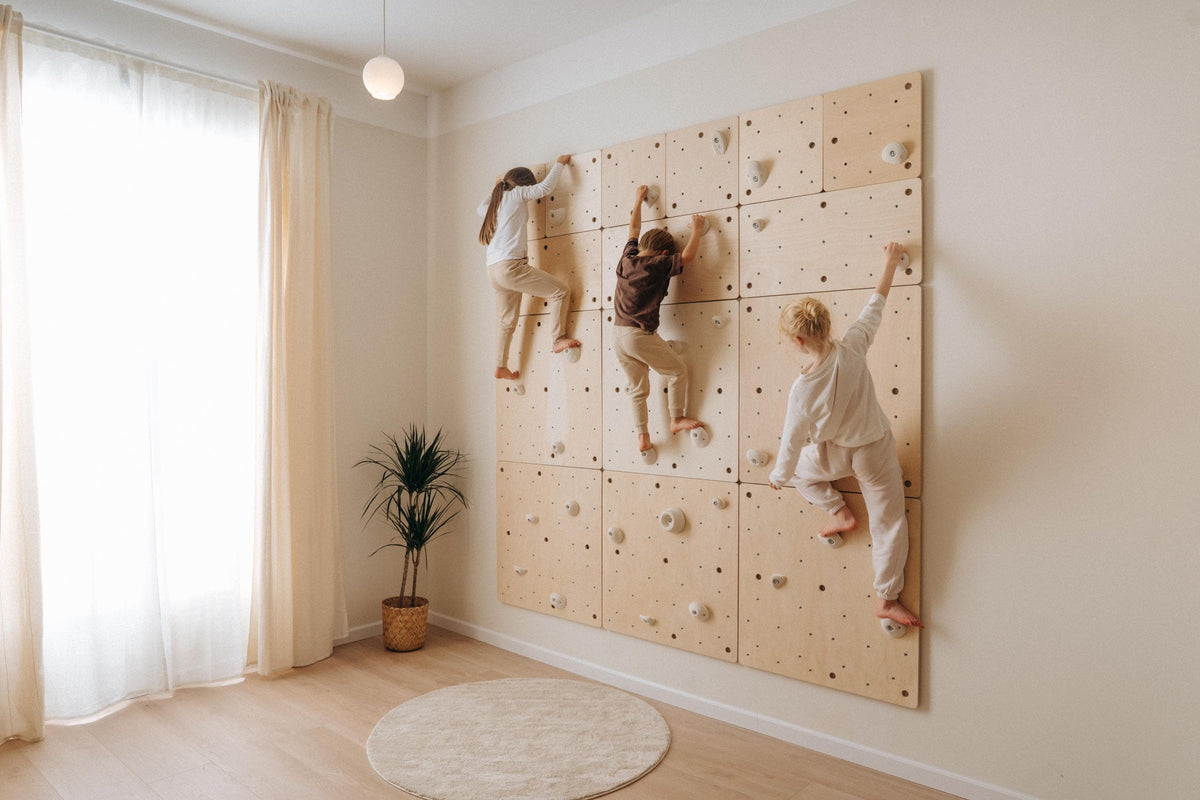 Kids wooden climbing wall with modular panels mounted on a wall