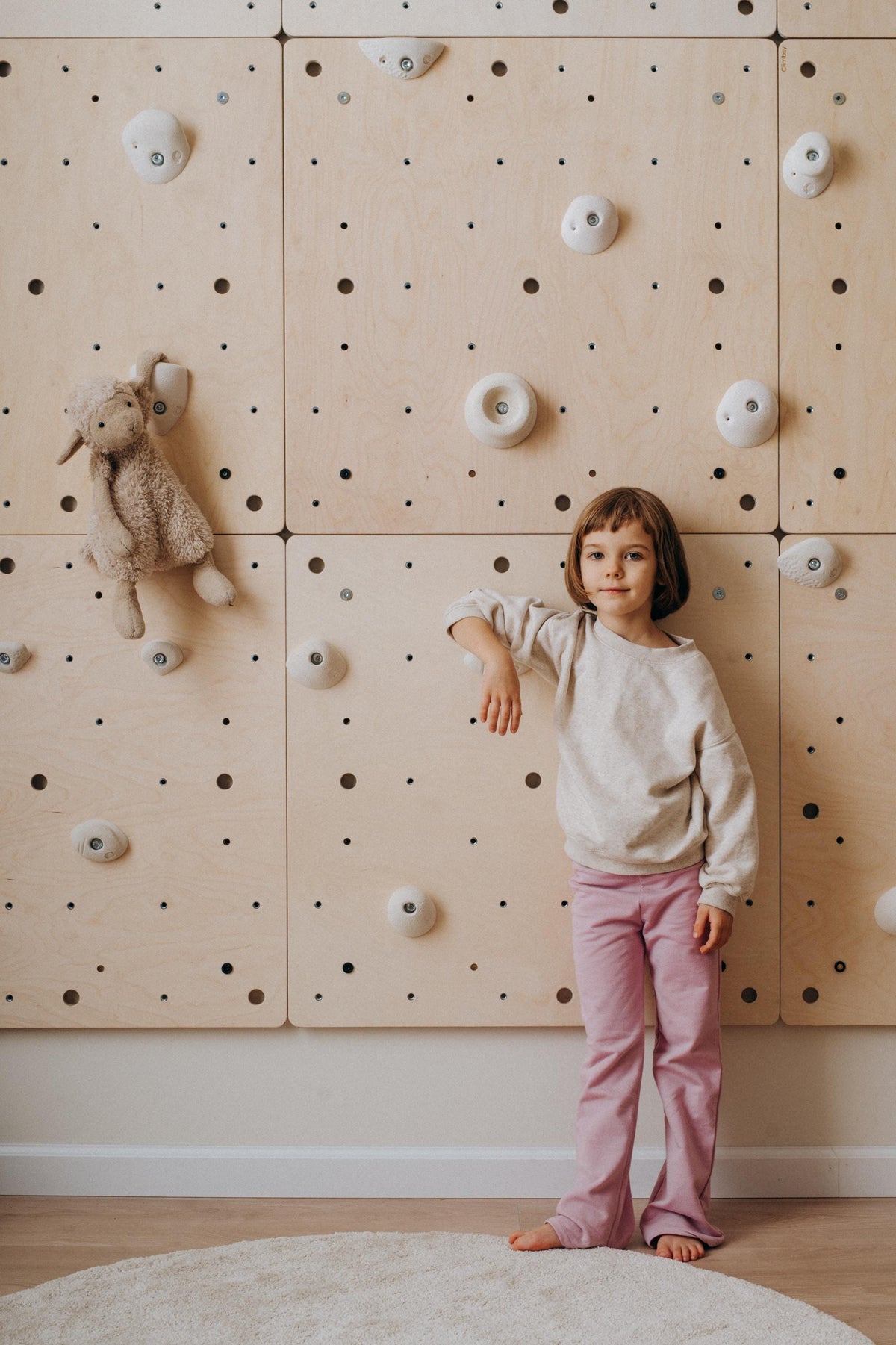 Climbsy wall panels with a plush toy hanging from a hold